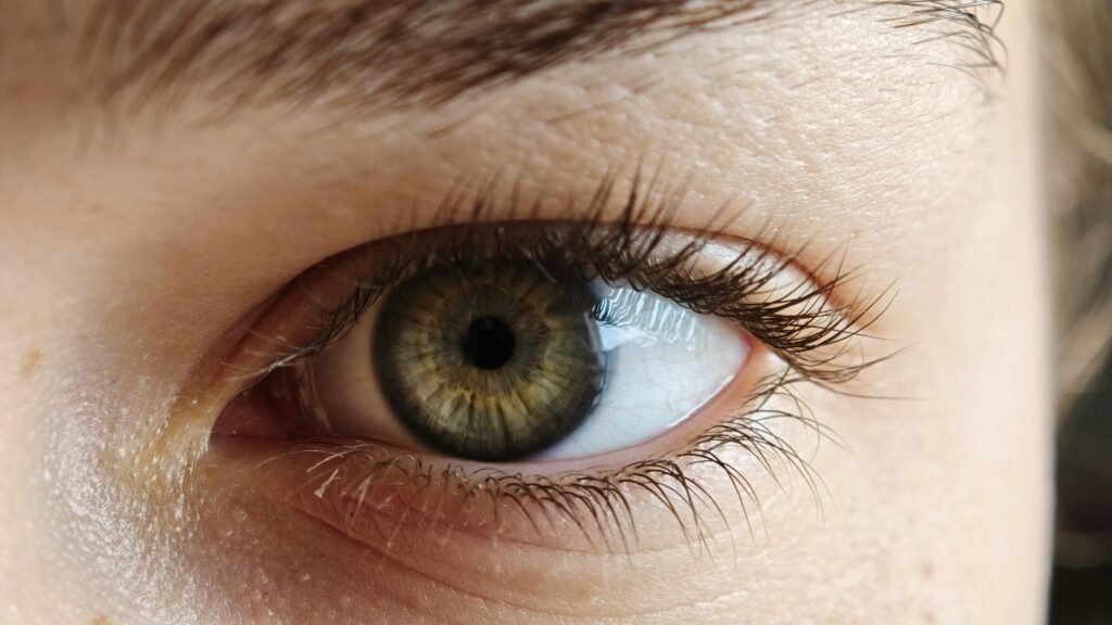 Detailed close-up of a green human eye showing natural patterns and textures.